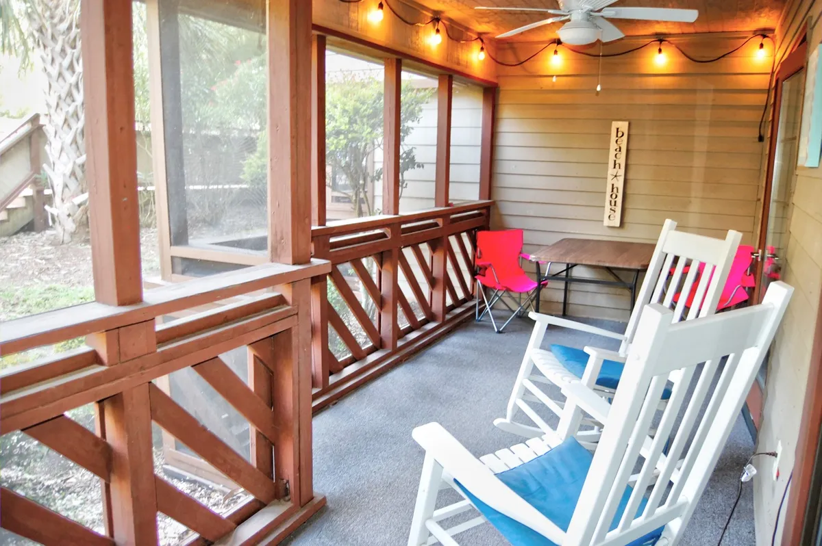 A cozy porch area with rocking chairs, string lights, and a small table, perfect for relaxing, reading, or chatting with friends while enjoying the fresh air.