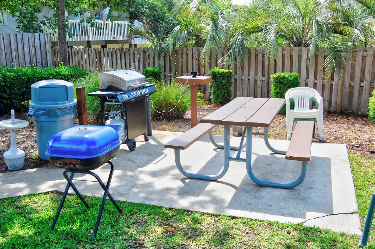This image highlights a picnic area outfitted with a grill, a picnic table, and outdoor seating—a perfect setting for barbecues, group gatherings, and family picnics. The sunny, open-air mood enhances the feeling of resort recreation and community.